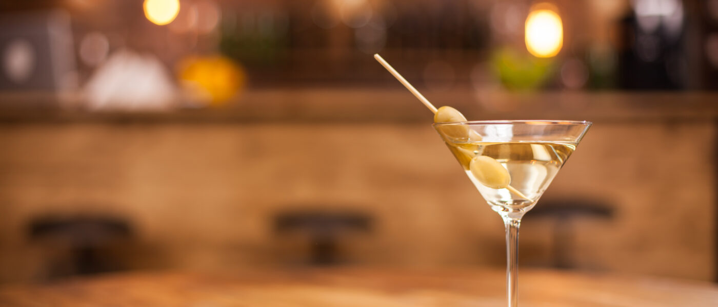 Verre de cocktail sur une table en bois dans un bar élégant au décor vintage