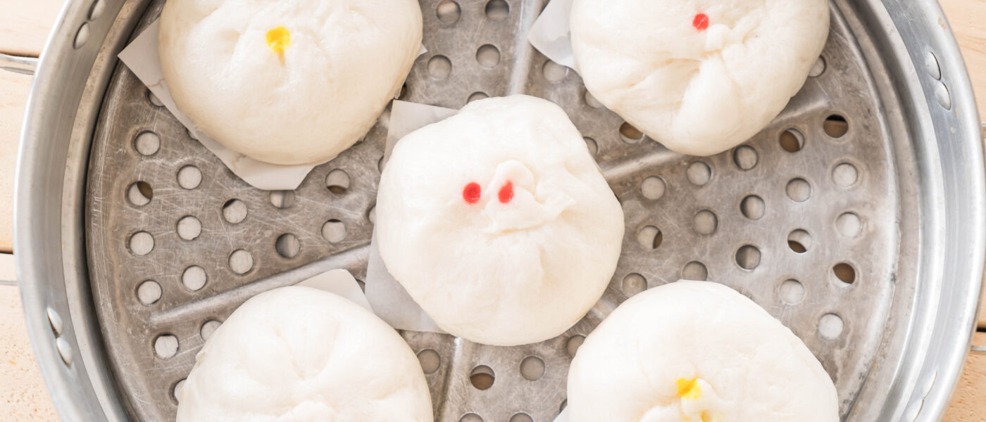 Baozi, brioches vapeur chinoises fourrées, disposées dans un panier en bambou