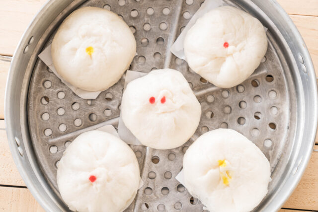 Baozi, brioches vapeur chinoises fourrées, disposées dans un panier en bambou