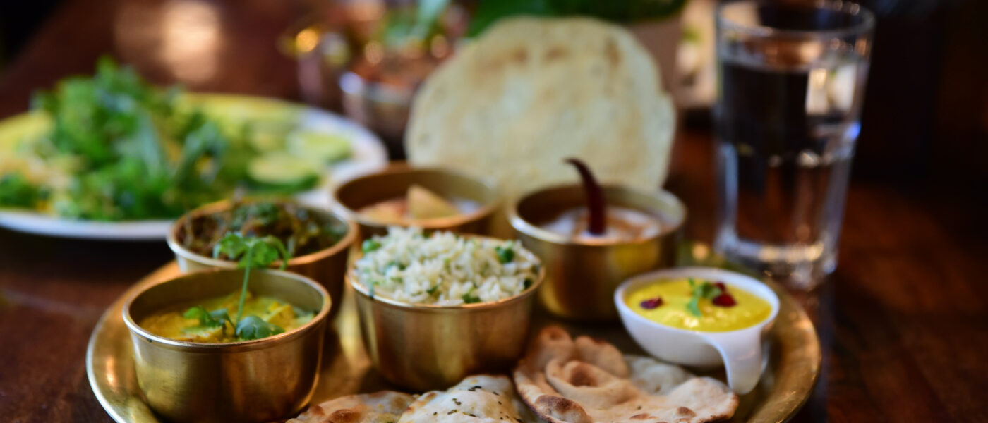 Thali végétarien traditionnel du nord de l'Inde, avec riz, pains et currys, servi sur une table en bois