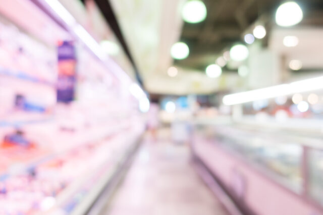 Allée de rayons réfrigérés dans un supermarché, sans personne visible