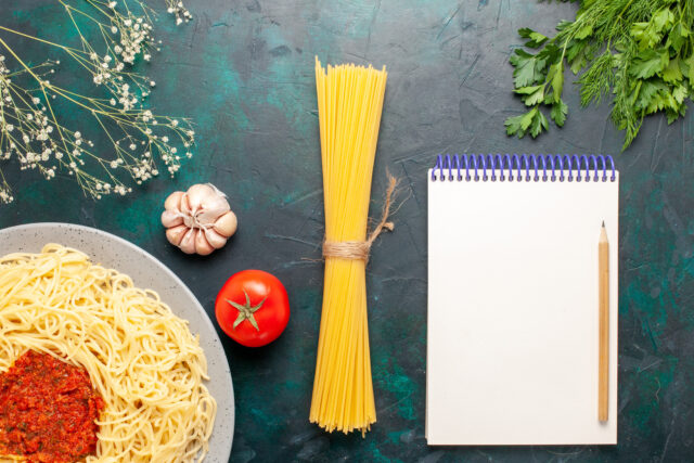 Assiette de pâtes italiennes vue de dessus, nappées de sauce tomate et de viande hachée