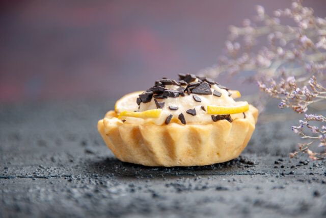 Tarte au citron vue de près, posée sur un fond sombre, sans personne visible